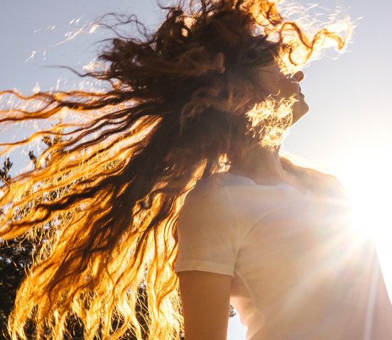 young female Pinnacle Wellness patient dancing in the sun